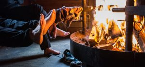 People warming feet in campfire.