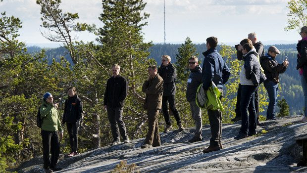 Forest academy participants on rocky forested hill.