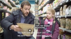 Mies näyttää kaupassa lapselle paperipakkausta, teksti: we must look after nature and so we need to use bio-based packaging. 