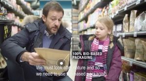 A man pointing a biopackage to a girl in a food store.