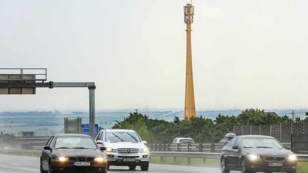 Traffic and in the background wooden telecommunication mast.