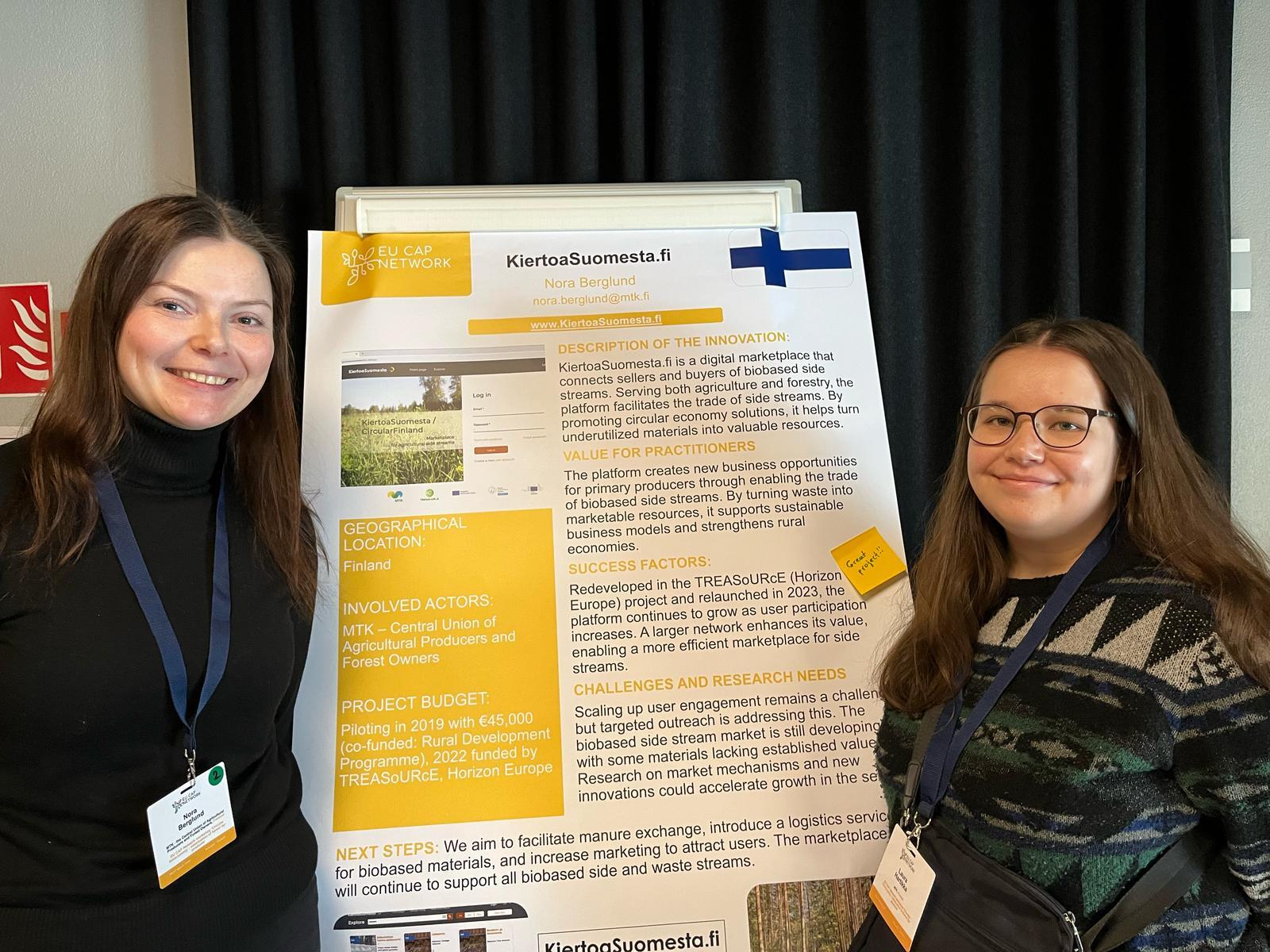 Nora Berglund ja Laura Hartikka seisomassa posterin edessä.